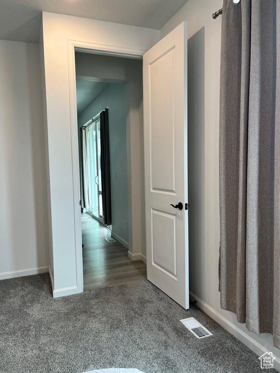 Hallway featuring carpet floors and baseboards