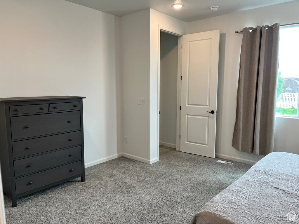 Bedroom with light carpet and baseboards