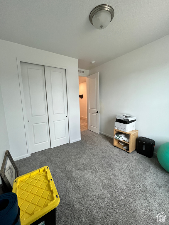Carpeted bedroom featuring a closet and baseboards