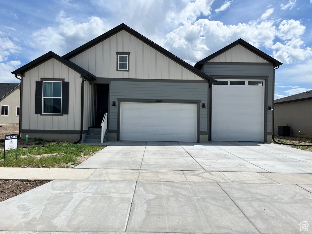 View of front of home with an attached garage, driveway, and board and batten siding