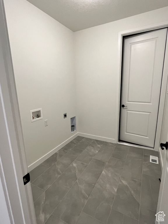 Laundry room with dark marble finish floors, washer hookup, electric dryer hookup, and baseboards