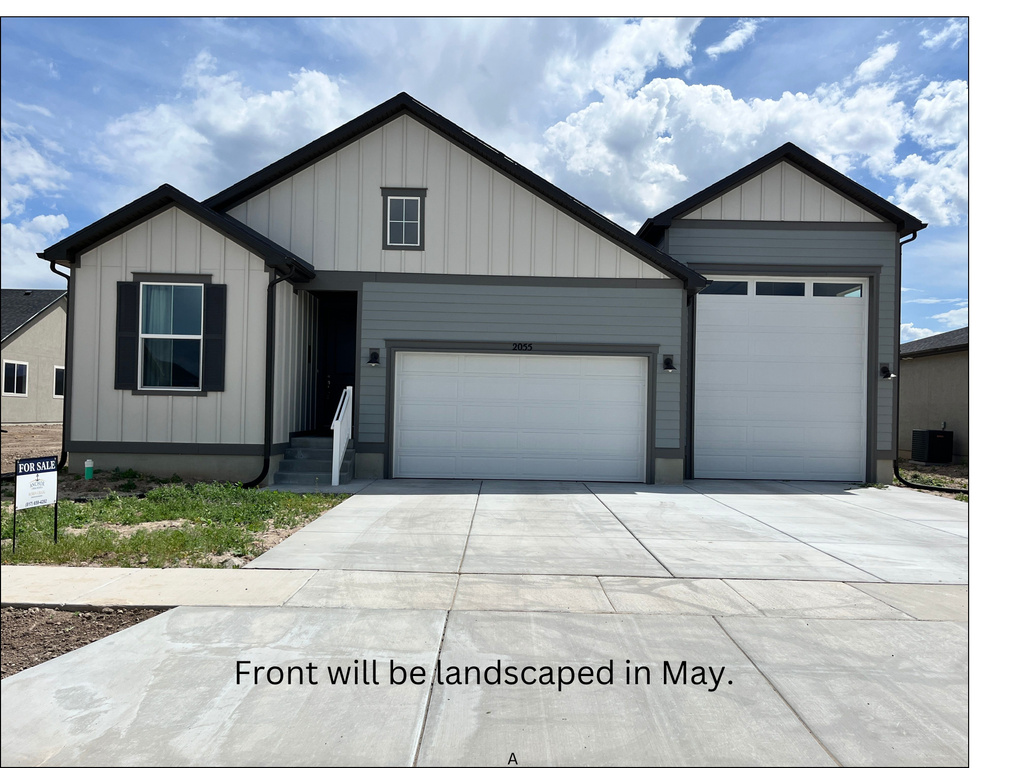 View of front facade with a garage, concrete driveway, and board and batten siding
