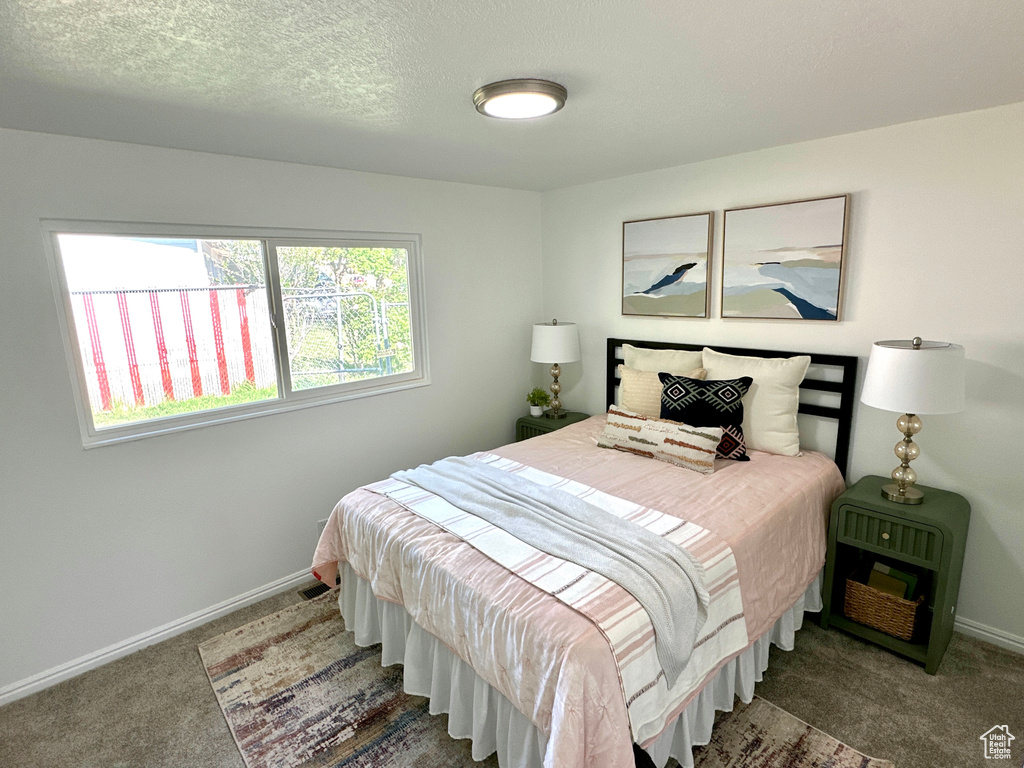Bedroom featuring carpet and baseboards