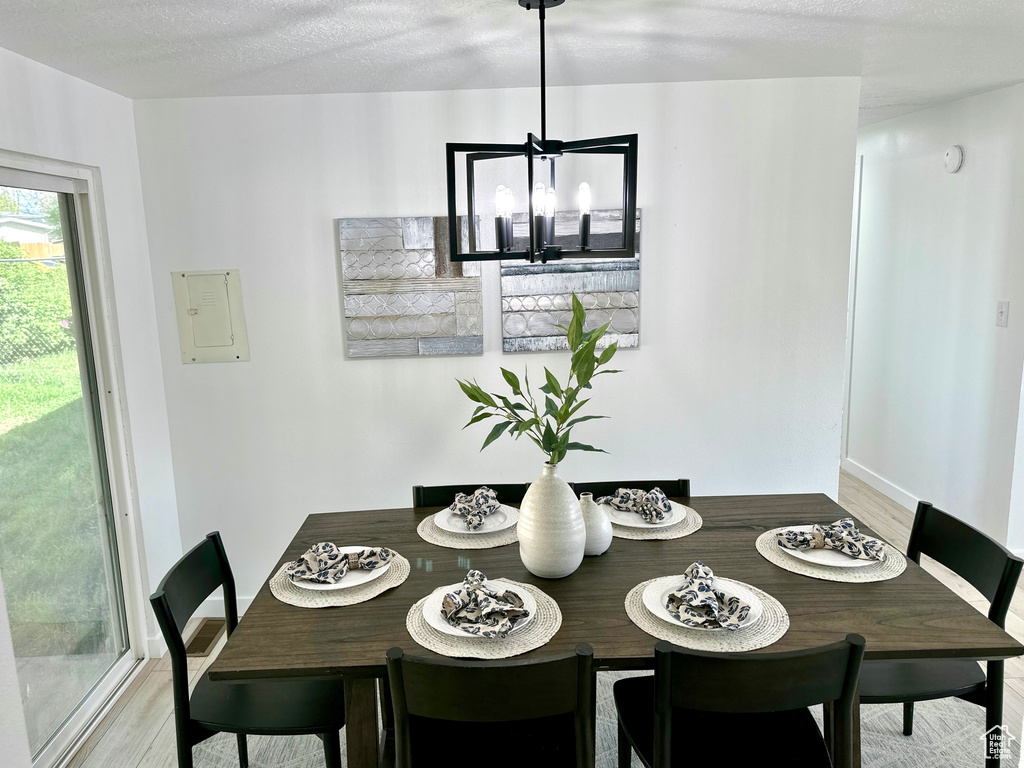 Dining room with light wood-style floors, baseboards, and a chandelier