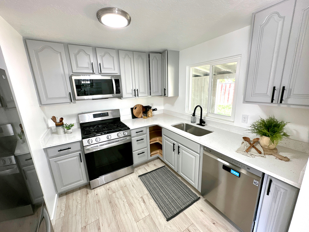 Kitchen with stainless steel appliances, a sink, and gray cabinets