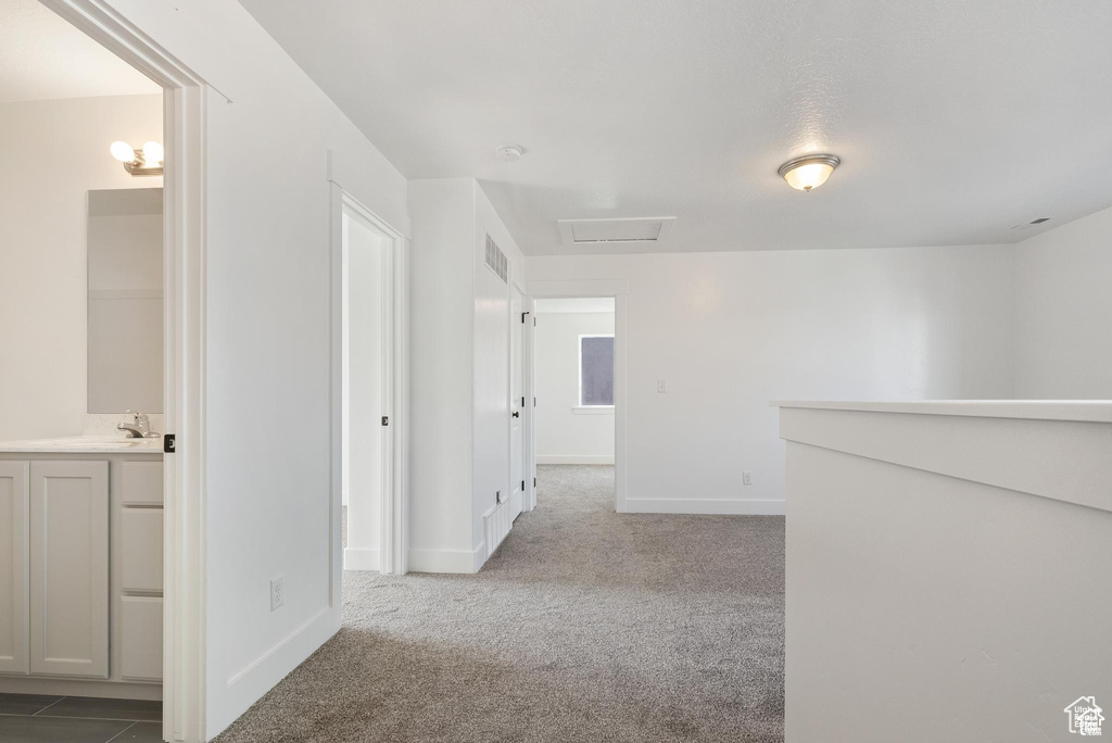 Hallway with carpet flooring and baseboards