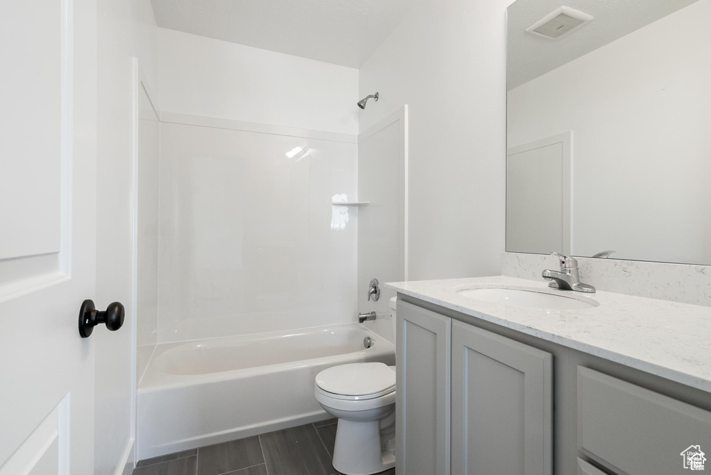 Full bathroom featuring bathtub / shower combination, vanity, toilet, and wood finished floors