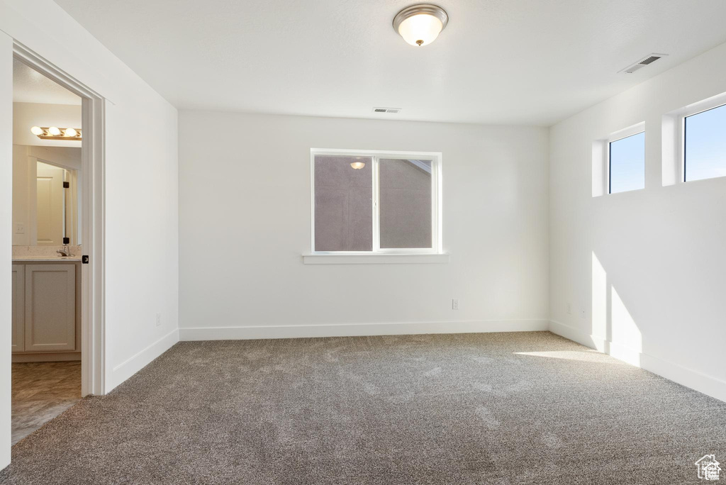 Carpeted empty room featuring baseboards