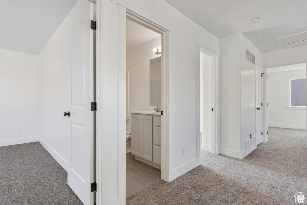 Hall with carpet flooring and baseboards