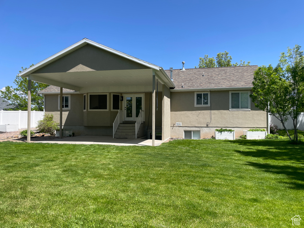 Back of property with stucco siding, entry steps, a patio, and roof with shingles