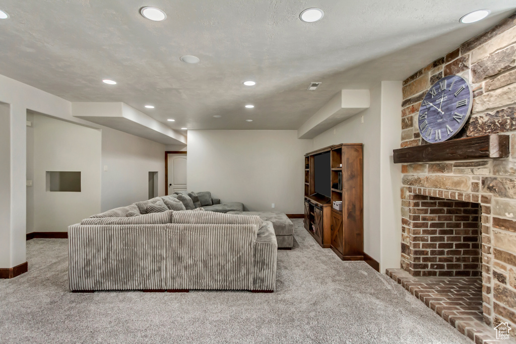 Living room featuring carpet floors, recessed lighting, baseboards, and a large fireplace