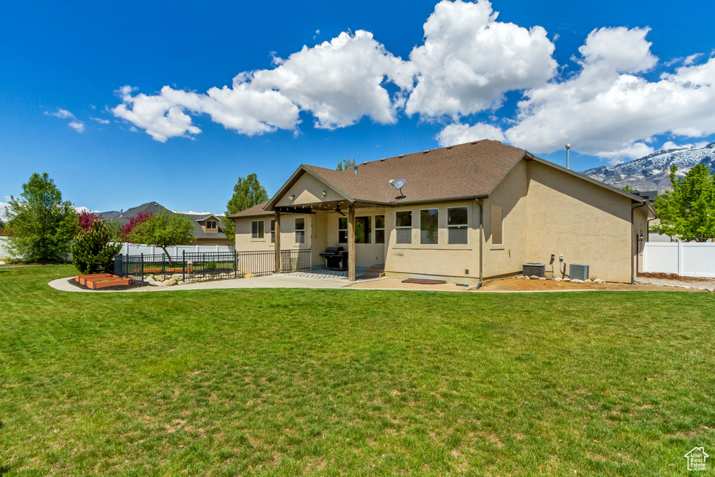 Back of property with a patio, stucco siding, central AC unit, and a ceiling fan