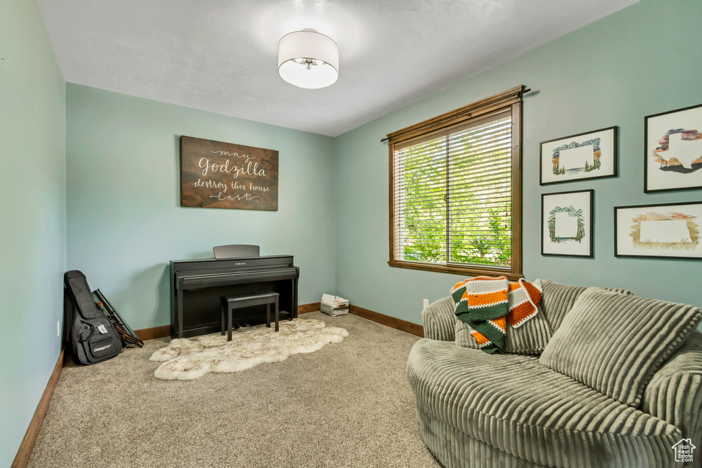 Living area featuring carpet flooring and baseboards