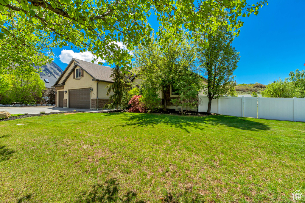 View of front of house with stucco siding, a garage, and driveway