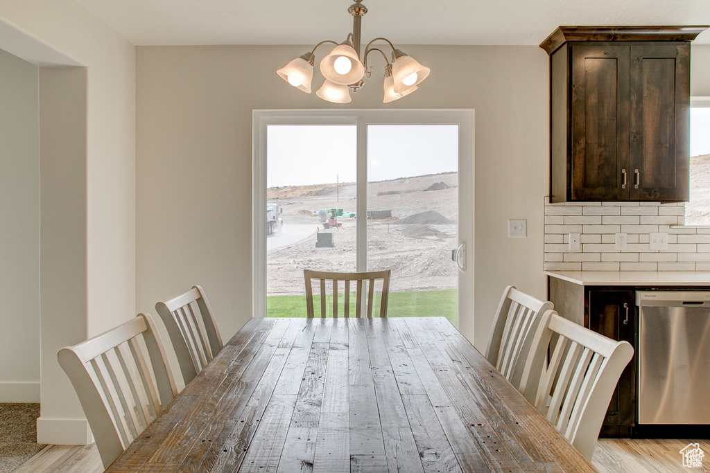 Dining area featuring healthy amount of natural light, a chandelier, and light wood-style flooring