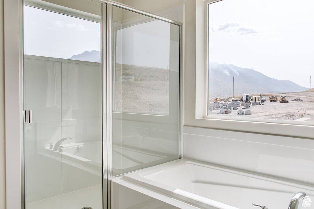 Full bathroom featuring a mountain view, a stall shower, and a tub to relax in