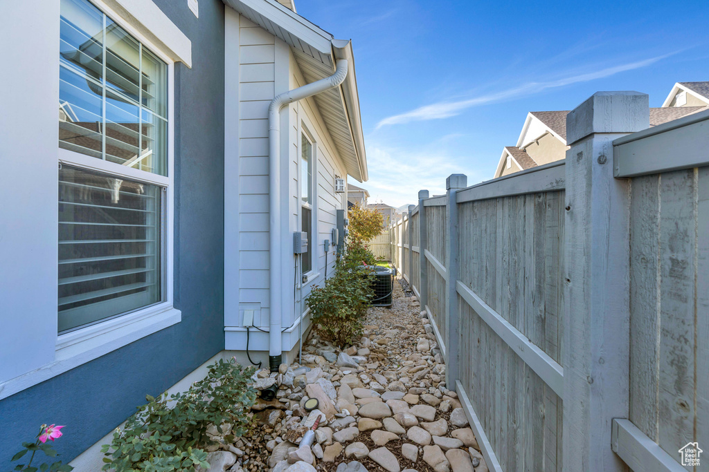 View of property exterior featuring fence and central AC unit