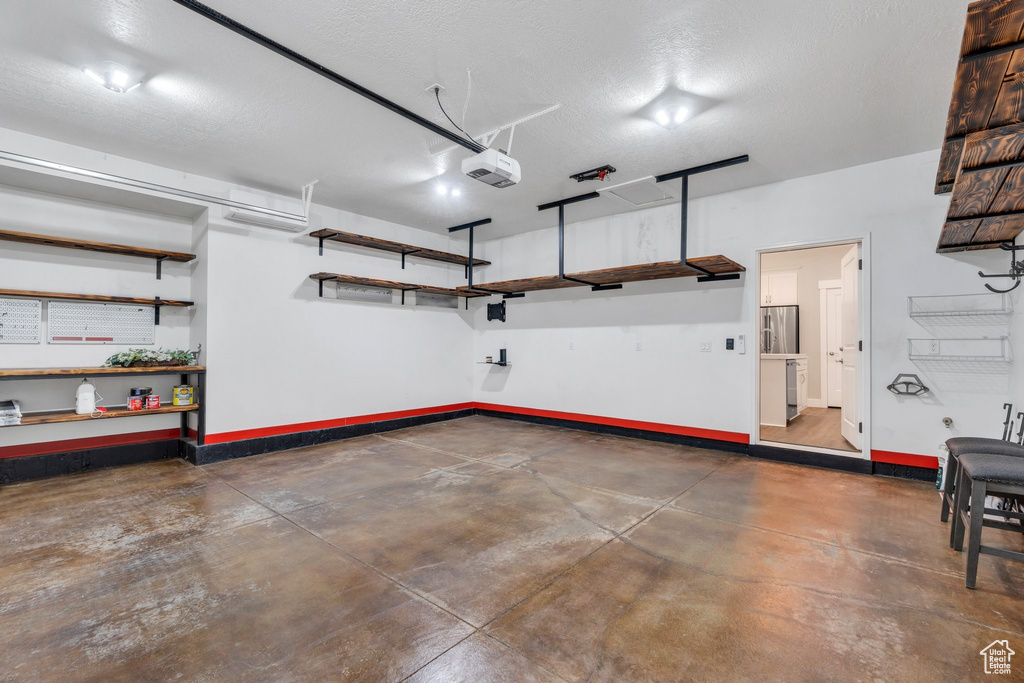 Garage featuring baseboards and a garage door opener