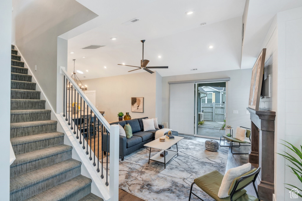 Living area featuring stairs, ceiling fan, recessed lighting, and vaulted ceiling