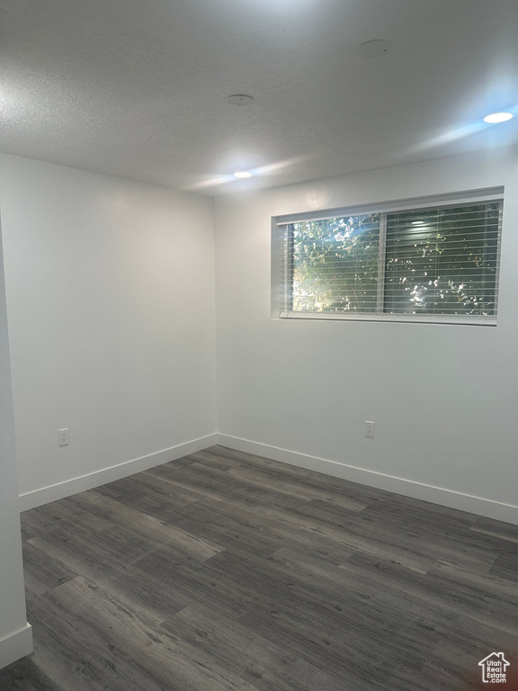 Empty room with dark wood-style floors and baseboards