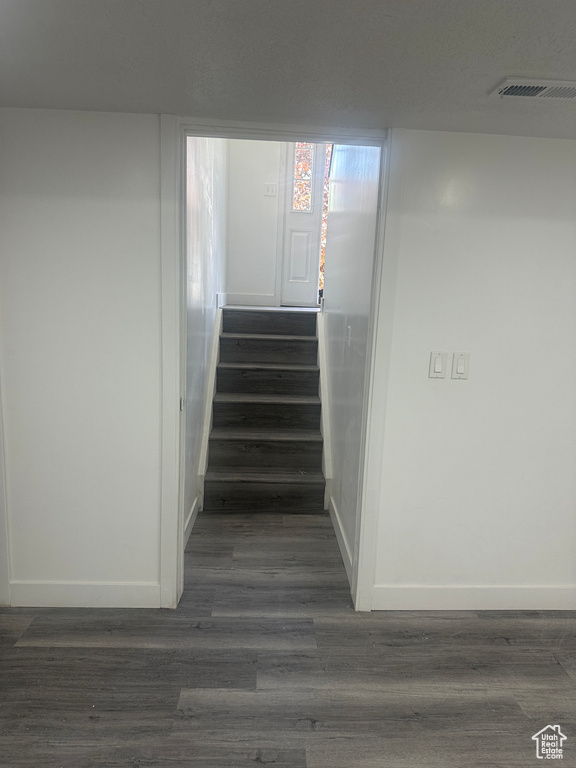 Staircase featuring baseboards and wood finished floors