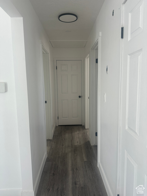Hall featuring dark wood finished floors and baseboards