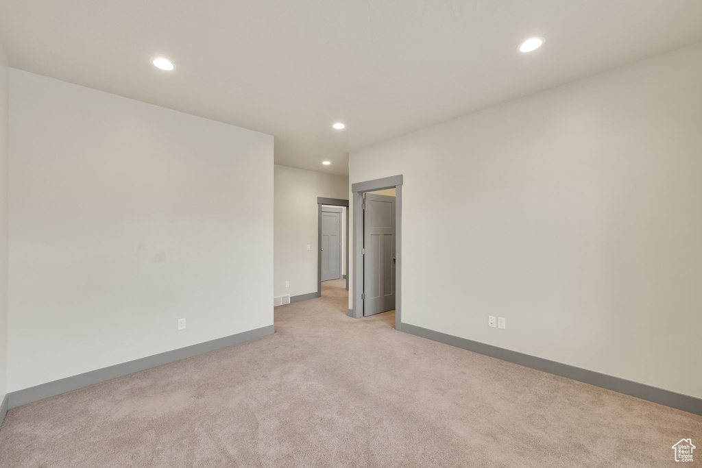 Spare room with light carpet, recessed lighting, and baseboards