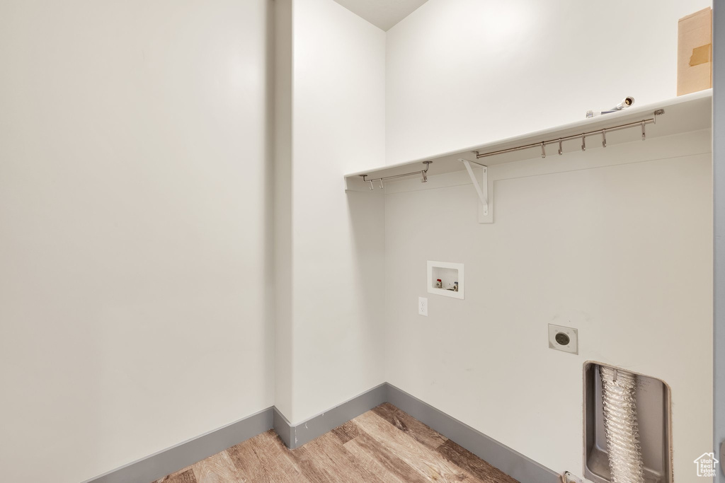 Laundry room featuring hookup for a washing machine, light wood-style floors, hookup for an electric dryer, and baseboards