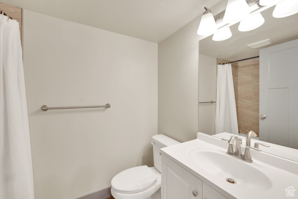 Full bath featuring toilet, vanity, and a shower with curtain