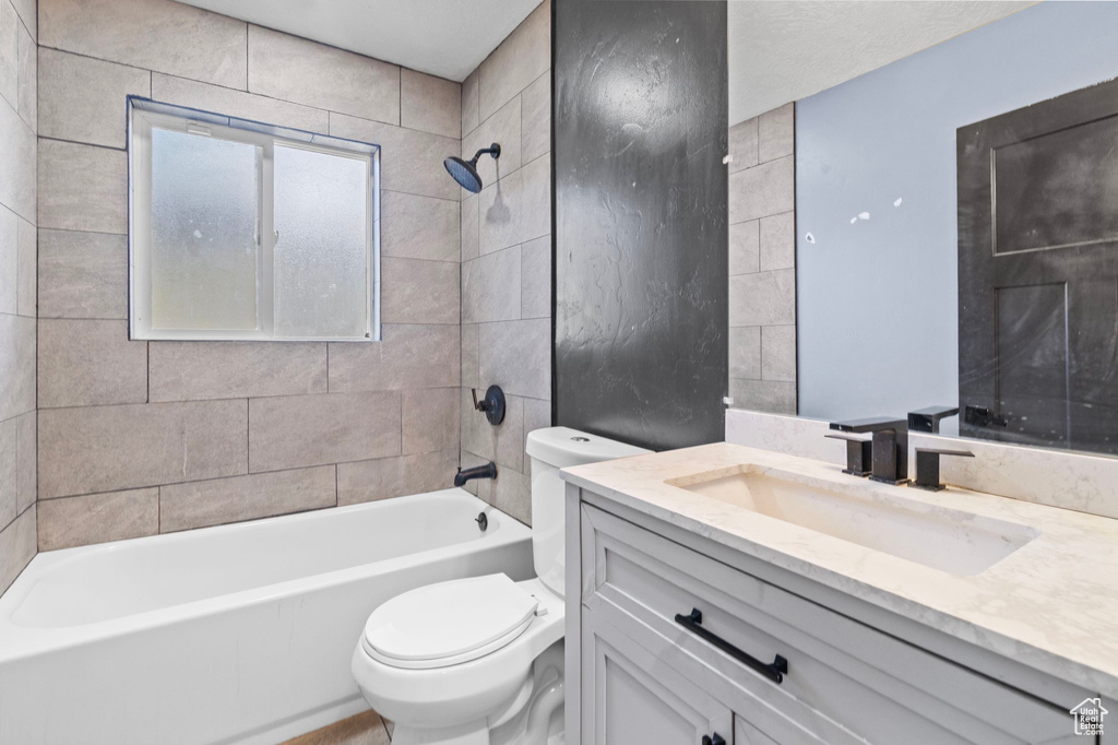Full bathroom featuring toilet, shower / tub combination, and vanity