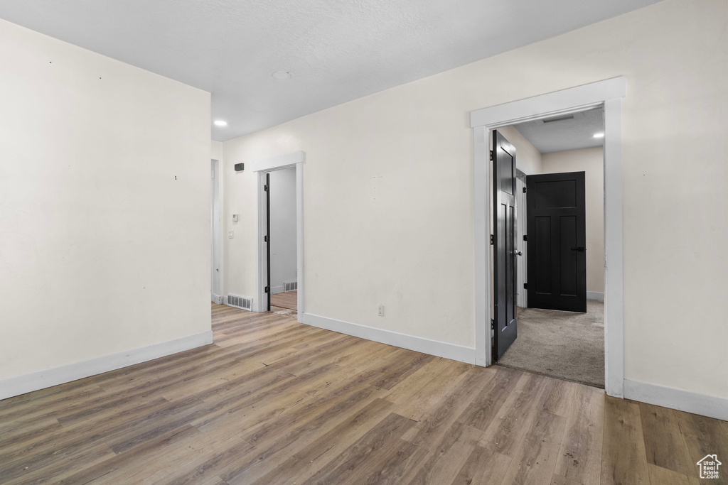 Unfurnished room with baseboards, wood finished floors, and recessed lighting