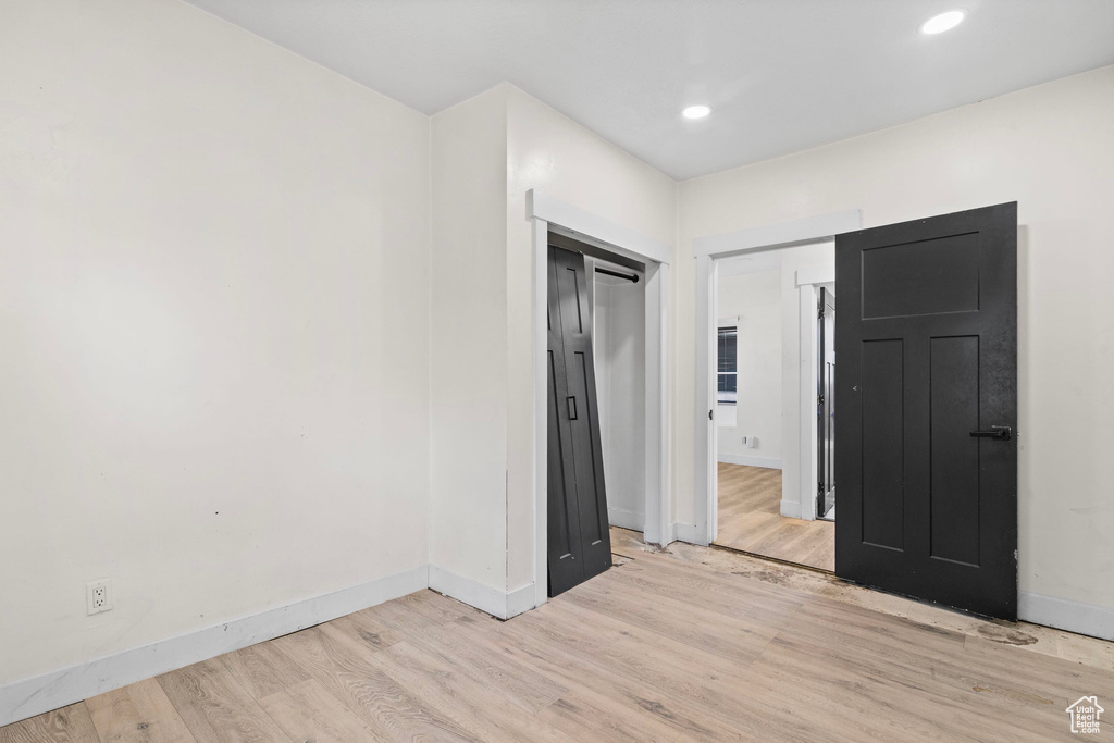 Unfurnished bedroom with light wood-type flooring, baseboards, and recessed lighting
