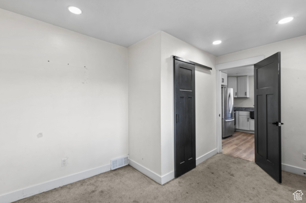 Unfurnished bedroom with freestanding refrigerator, carpet flooring, baseboards, and recessed lighting