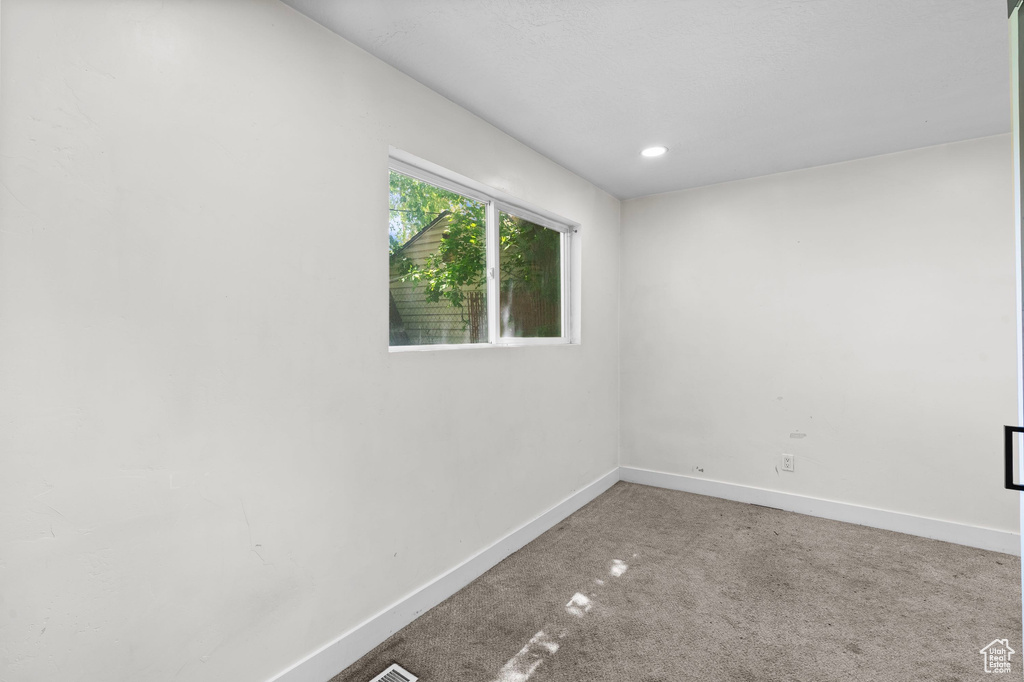 Carpeted empty room featuring baseboards