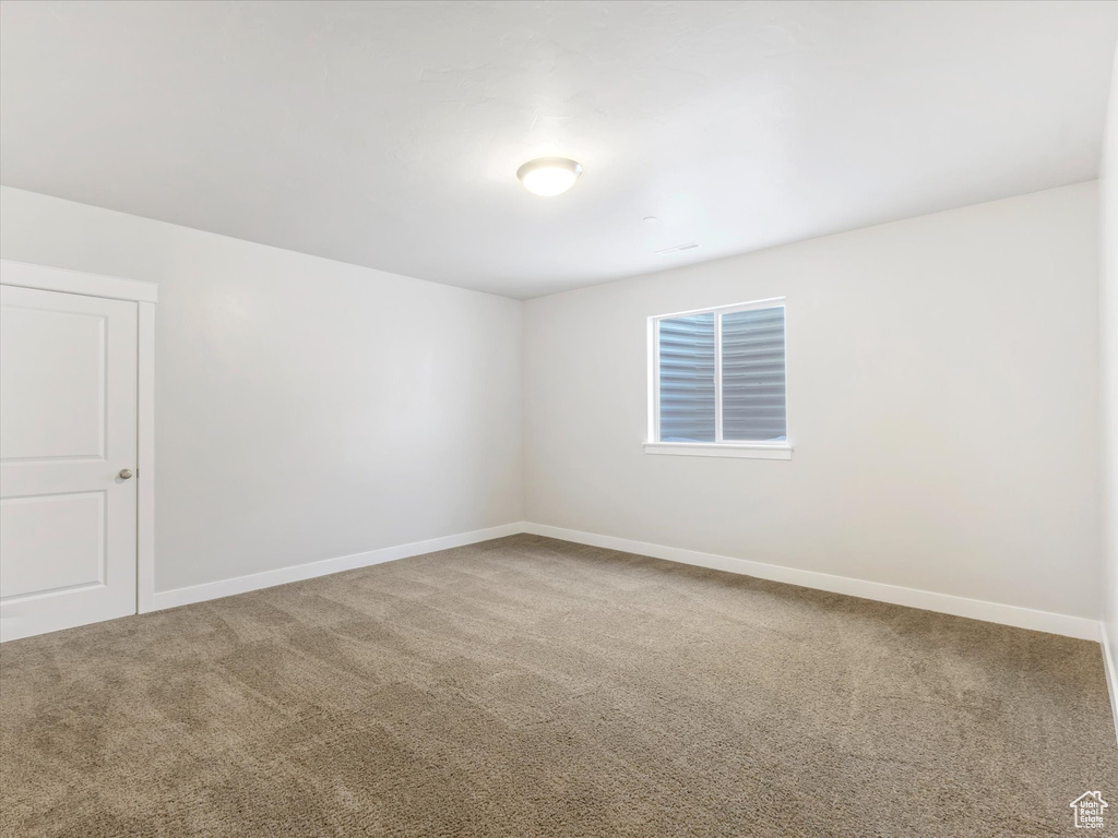 Unfurnished room featuring carpet and baseboards