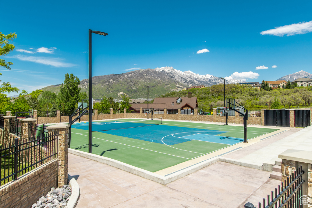 View of basketball court with community basketball court, a mountain view, and fence