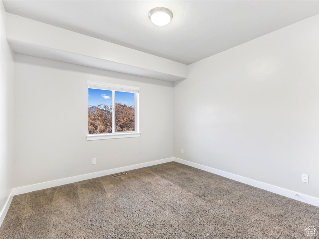Carpeted empty room featuring baseboards