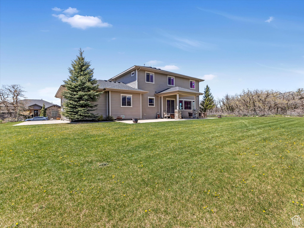 Rear view of house featuring a lawn and a patio