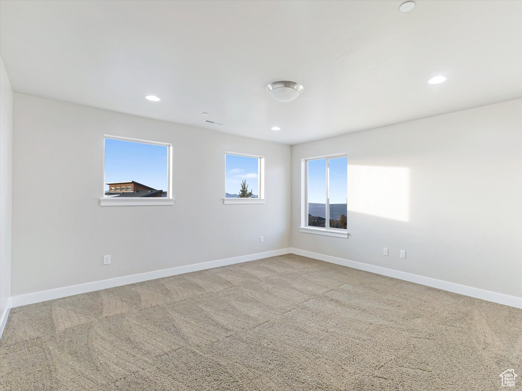 Spare room featuring carpet flooring, baseboards, and recessed lighting