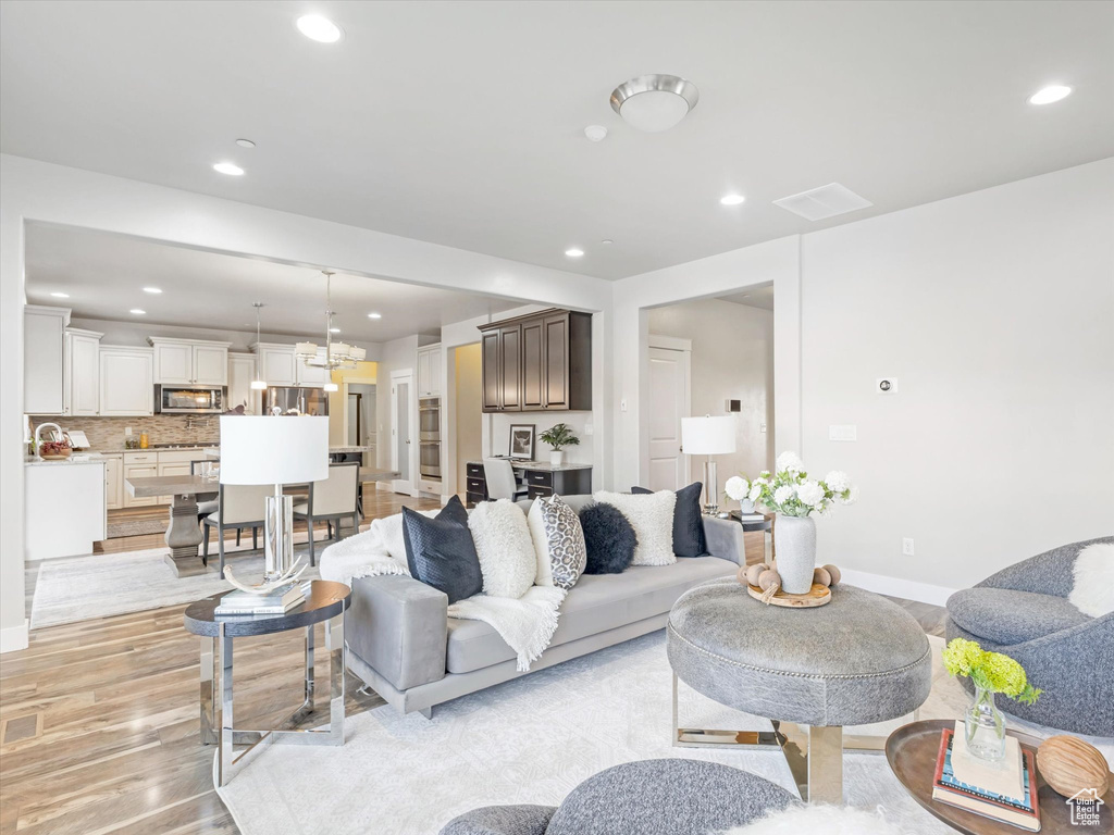 Living area with recessed lighting, light wood finished floors, and baseboards