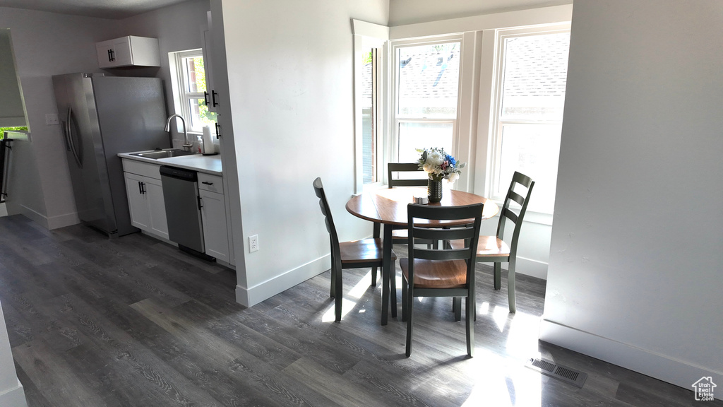 Dining space with dark wood-type flooring and baseboards