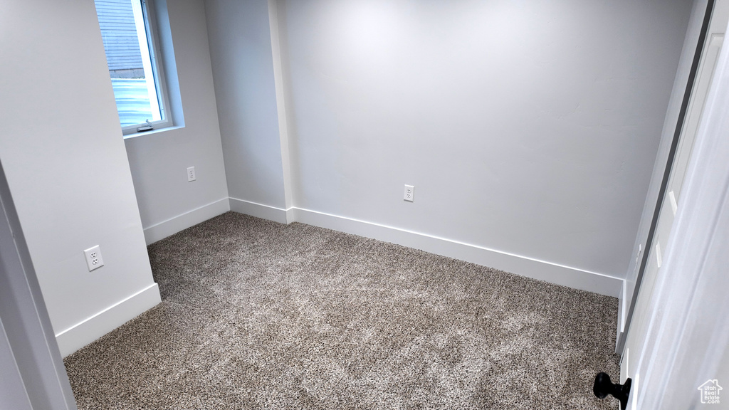 Spare room featuring carpet flooring and baseboards