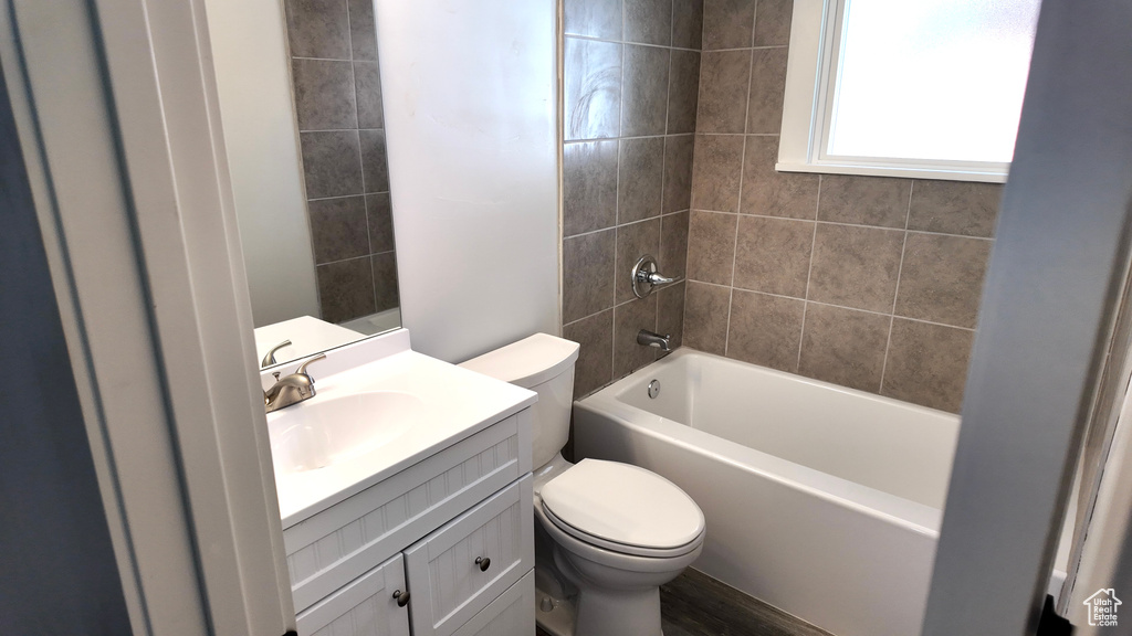 Bathroom featuring toilet, vanity, and shower / washtub combination