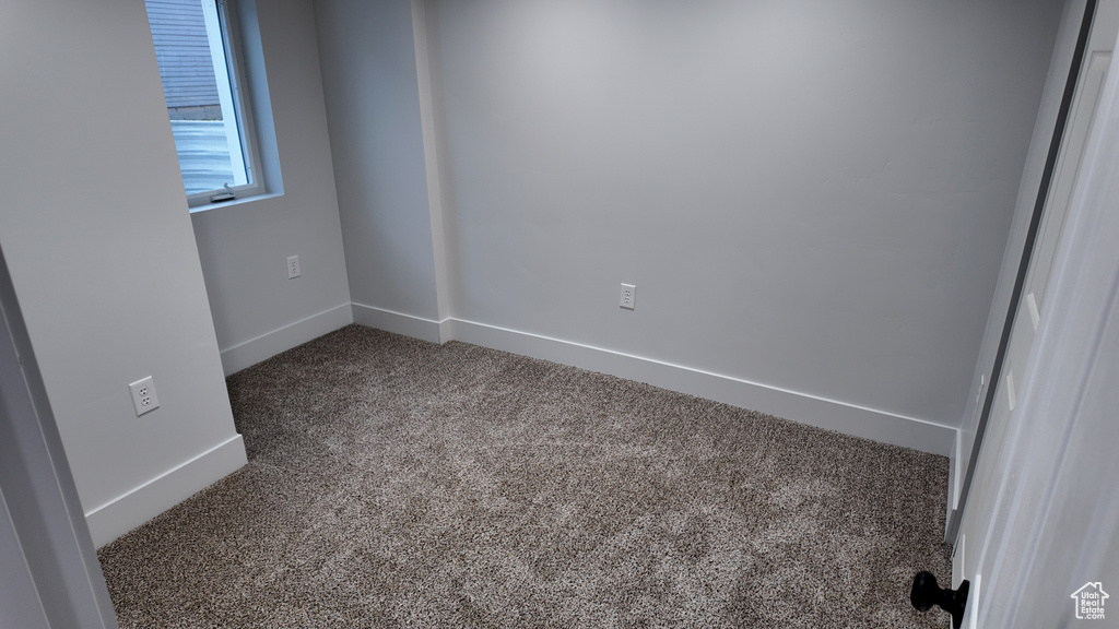 Carpeted spare room with baseboards