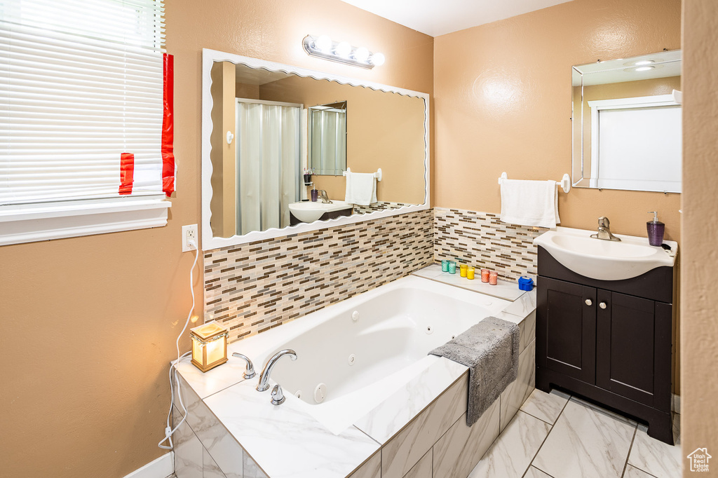 Full bath with a jetted tub, vanity, marble finish flooring, and a shower with curtain