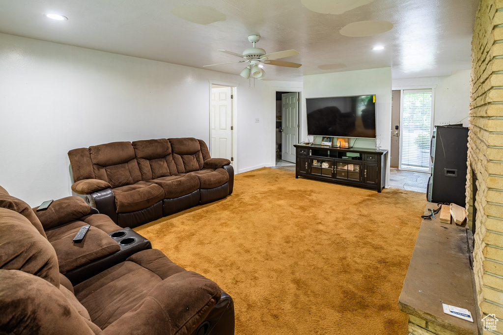 Carpeted living room with a ceiling fan and recessed lighting