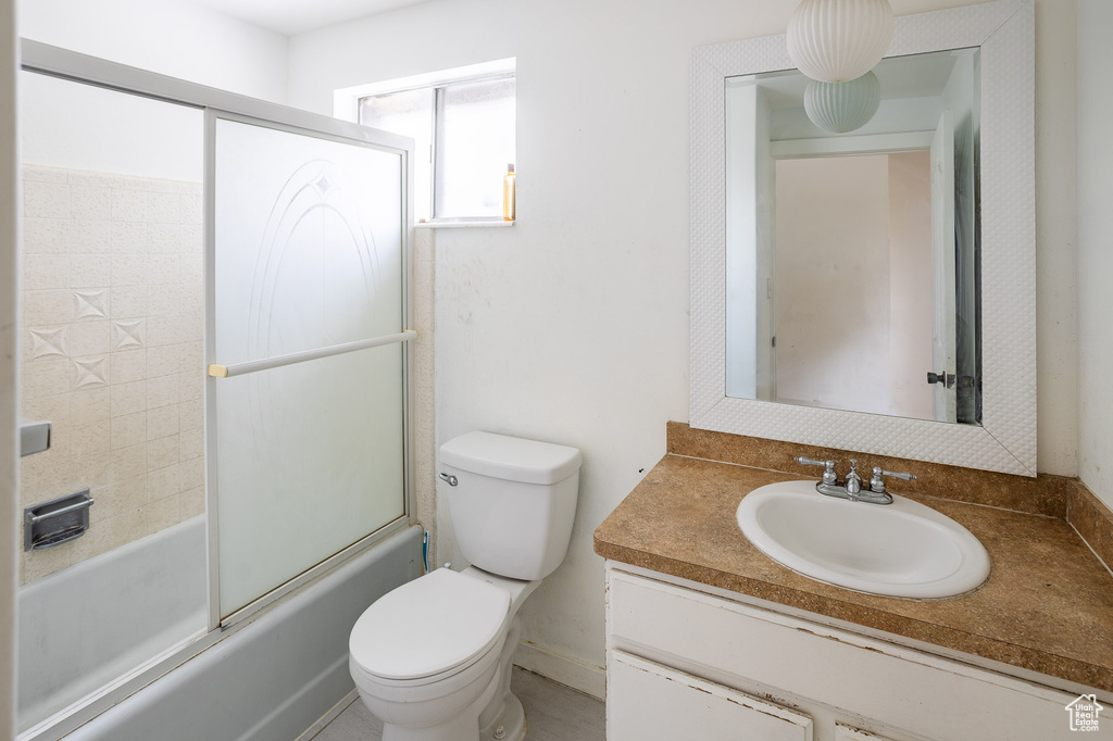 Full bath with toilet, vanity, and enclosed tub / shower combo