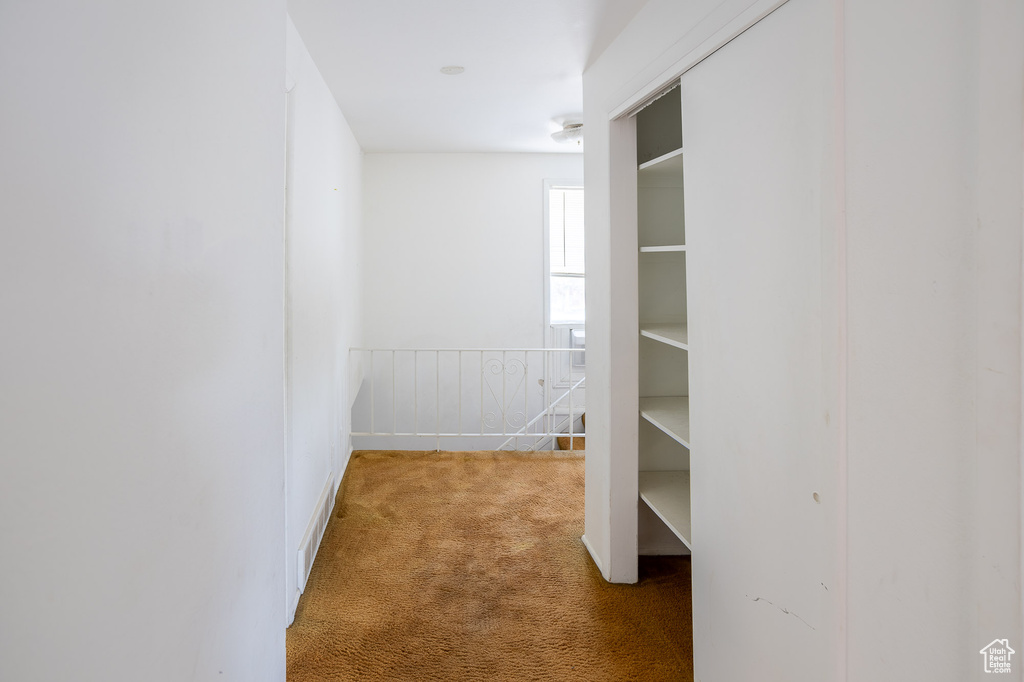 Hall with carpet and an upstairs landing