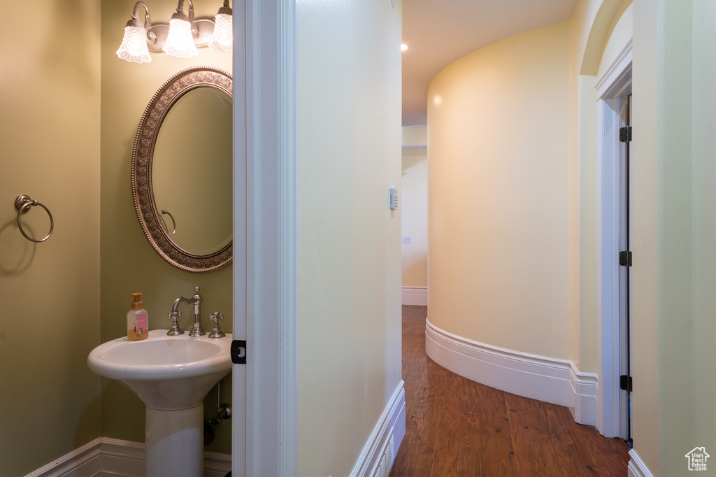 Bathroom with wood finished floors and a chandelier