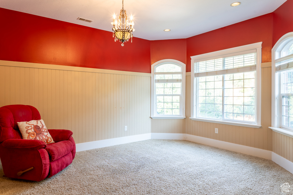 Living area featuring carpet, plenty of natural light, wainscoting, a chandelier, and recessed lighting